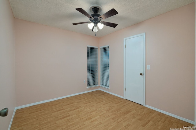 spare room with a textured ceiling, ceiling fan, and light hardwood / wood-style flooring