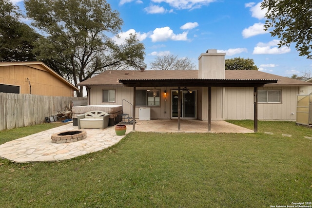 rear view of house with a lawn, an outdoor fire pit, and a patio