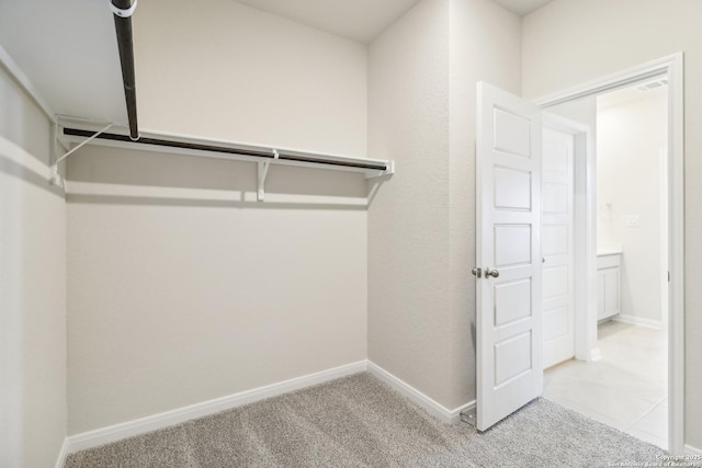 walk in closet with light colored carpet