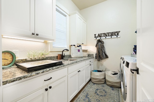 laundry room featuring cabinets, separate washer and dryer, and sink