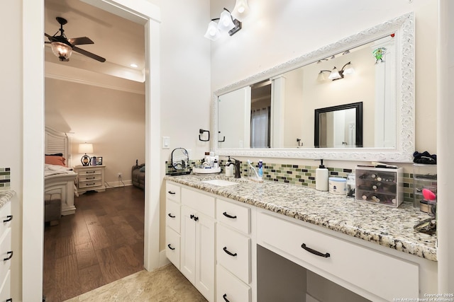 bathroom featuring hardwood / wood-style flooring, ceiling fan, tasteful backsplash, ornamental molding, and vanity