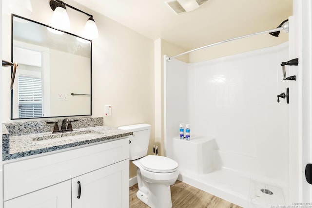 bathroom with toilet, walk in shower, hardwood / wood-style floors, and vanity