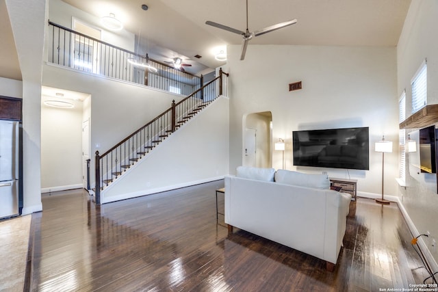 living room with high vaulted ceiling, ceiling fan, and dark wood-type flooring