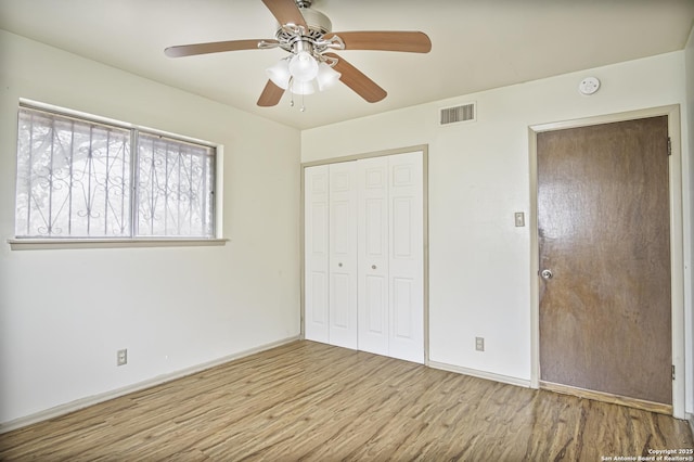 unfurnished bedroom with ceiling fan, light hardwood / wood-style flooring, and a closet