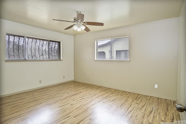 spare room featuring ceiling fan, a healthy amount of sunlight, and light wood-type flooring