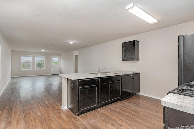 kitchen featuring a textured ceiling, sink, light hardwood / wood-style floors, and black appliances