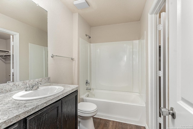 full bathroom with toilet,  shower combination, hardwood / wood-style floors, and vanity