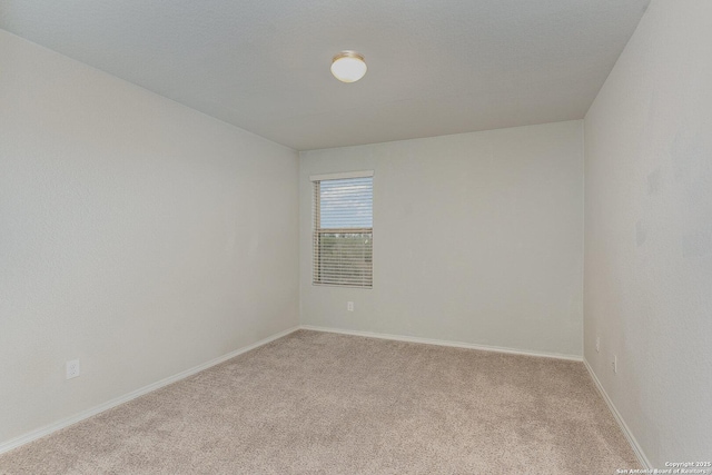 spare room featuring light colored carpet