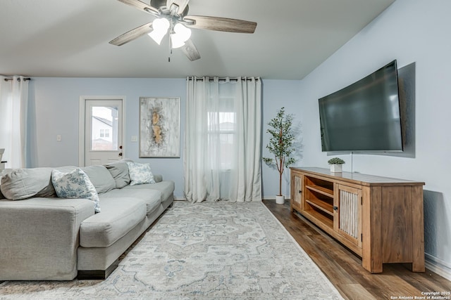 living room featuring dark wood-type flooring and ceiling fan