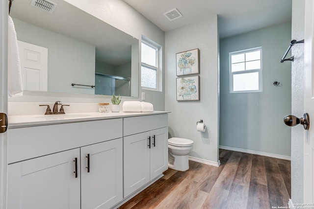 bathroom featuring a shower with door, hardwood / wood-style floors, toilet, and vanity