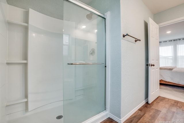 bathroom featuring hardwood / wood-style floors and a shower with door