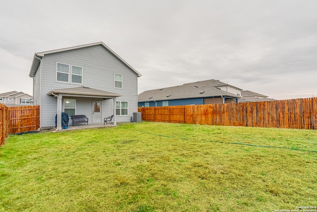 back of house with a yard and a patio