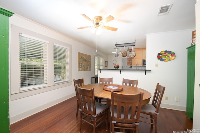 dining room featuring ceiling fan, a healthy amount of sunlight, and dark wood-type flooring