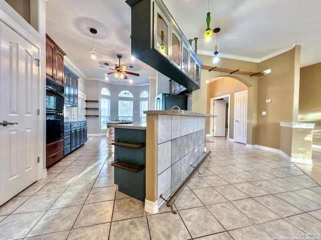 kitchen featuring kitchen peninsula, ceiling fan, light tile patterned flooring, stainless steel refrigerator, and ornamental molding