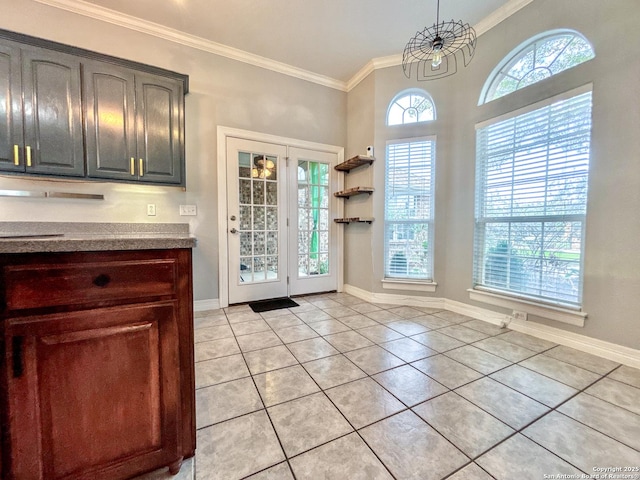 doorway with a notable chandelier, light tile patterned flooring, and crown molding