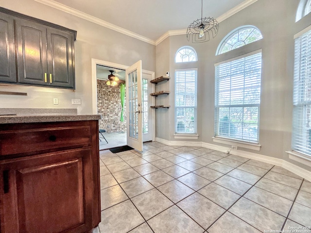 kitchen with light tile patterned floors, french doors, a notable chandelier, and ornamental molding