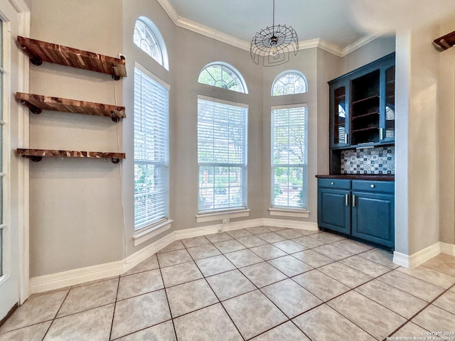 unfurnished dining area featuring crown molding and light tile patterned flooring