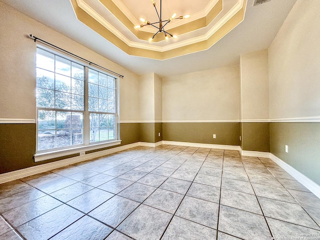 empty room with a raised ceiling, light tile patterned flooring, an inviting chandelier, and ornamental molding