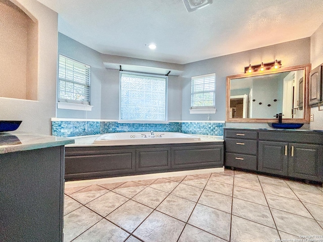 bathroom with tile patterned flooring, a tub to relax in, and vanity