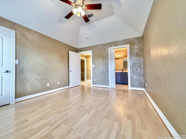 unfurnished bedroom featuring light hardwood / wood-style floors, ensuite bathroom, high vaulted ceiling, and ceiling fan