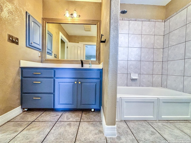 bathroom featuring tile patterned floors, tiled shower / bath, and vanity