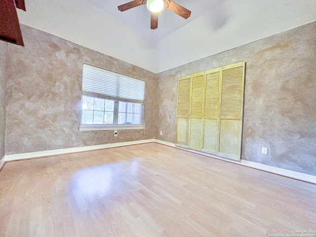 unfurnished room featuring lofted ceiling, light wood-type flooring, and ceiling fan