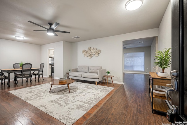 living room with ceiling fan and dark hardwood / wood-style floors