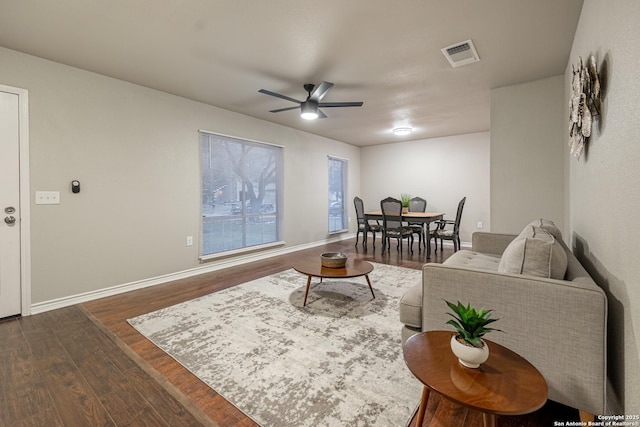 living room with ceiling fan and dark hardwood / wood-style flooring