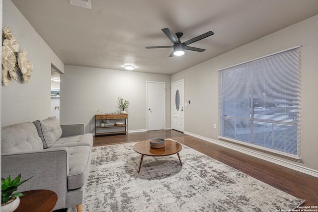 living room featuring ceiling fan and dark hardwood / wood-style floors