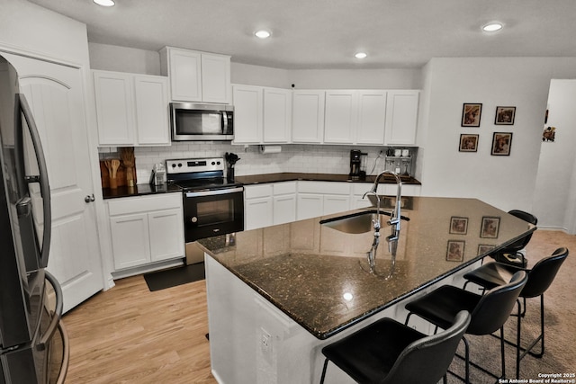 kitchen with decorative backsplash, sink, white cabinetry, and stainless steel appliances