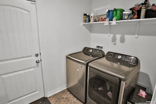 washroom with separate washer and dryer and dark tile patterned floors