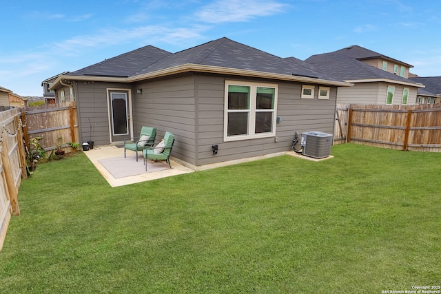 rear view of house with a patio area, central AC unit, and a lawn