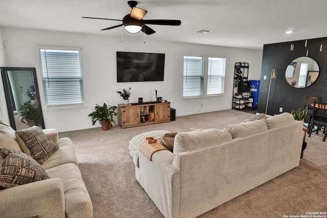 carpeted living room with ceiling fan