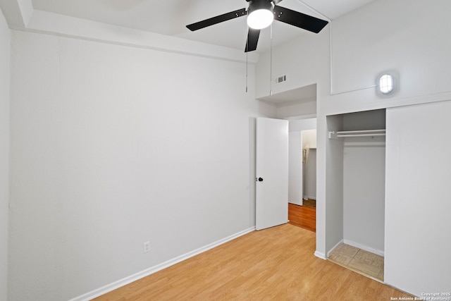 unfurnished bedroom featuring light hardwood / wood-style floors, a closet, and ceiling fan