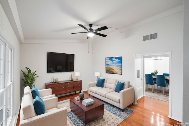 living room with light wood-type flooring, ceiling fan, and lofted ceiling