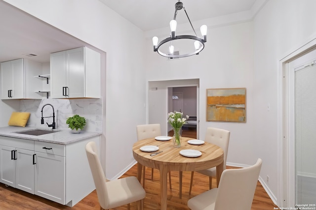 dining space featuring a notable chandelier, light hardwood / wood-style floors, and sink