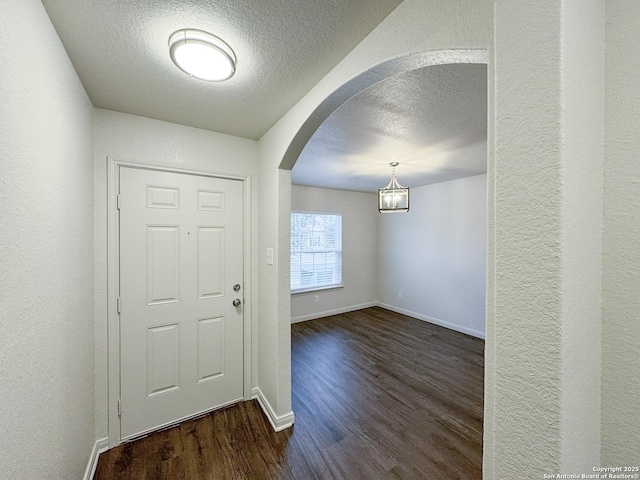 entrance foyer with a textured ceiling and dark hardwood / wood-style floors