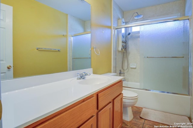 full bathroom featuring toilet, vanity, tile patterned flooring, and shower / bath combination with glass door