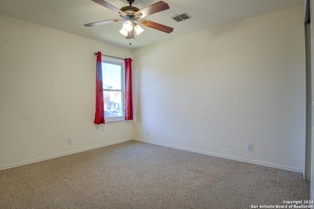 carpeted spare room with ceiling fan