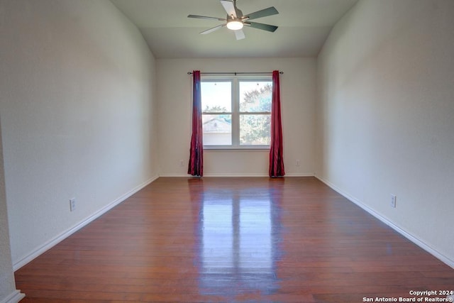 unfurnished room featuring ceiling fan, dark hardwood / wood-style flooring, and vaulted ceiling