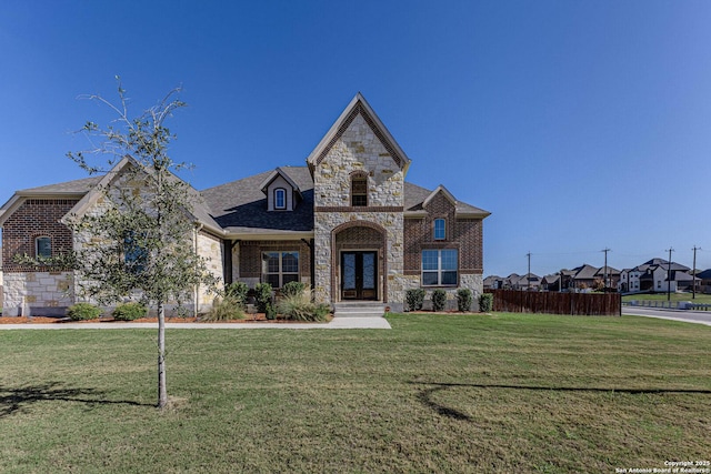 french country inspired facade with a front yard and french doors