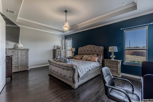 bedroom featuring ceiling fan, a tray ceiling, dark hardwood / wood-style flooring, and crown molding