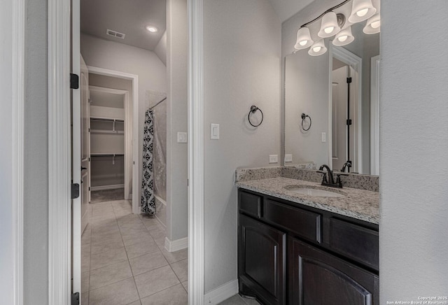 bathroom with tile patterned flooring, shower / bath combo, and vanity