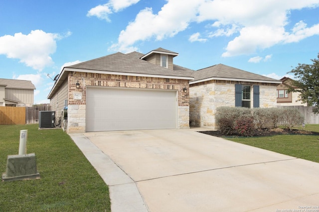 view of front of home featuring a garage, a front lawn, and central AC unit