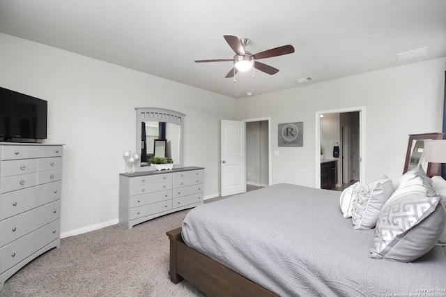 bedroom featuring ceiling fan, light colored carpet, and ensuite bathroom