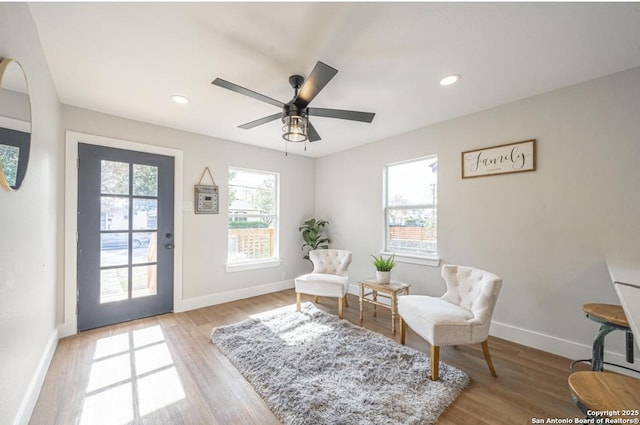 living area featuring ceiling fan and light wood-type flooring