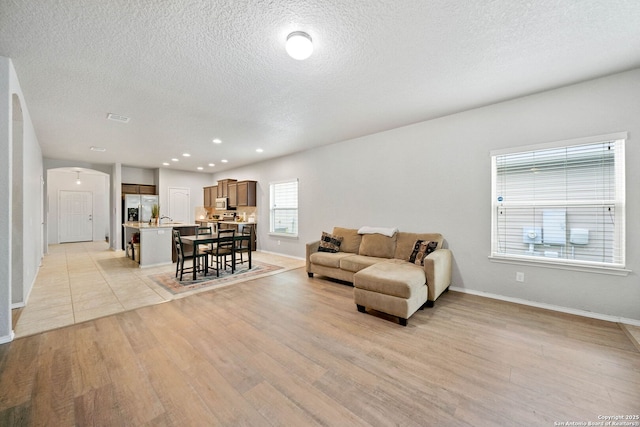 living room featuring a textured ceiling and light hardwood / wood-style floors