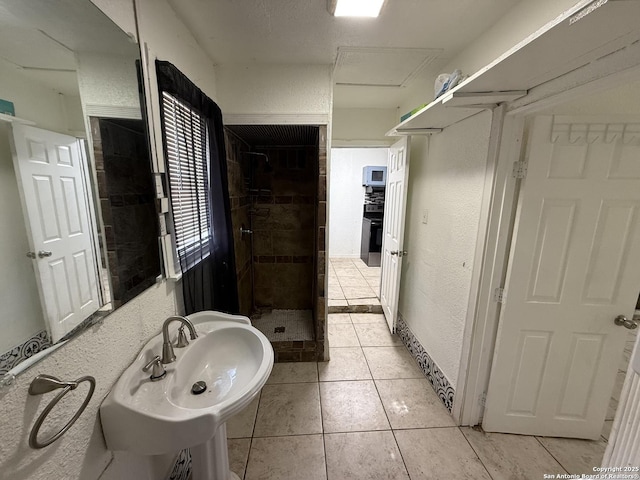 bathroom with sink, tile patterned floors, and a tile shower