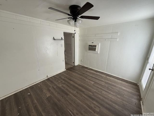 spare room with ceiling fan, an AC wall unit, and dark wood-type flooring