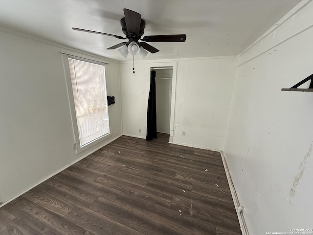 unfurnished bedroom with ceiling fan and dark wood-type flooring